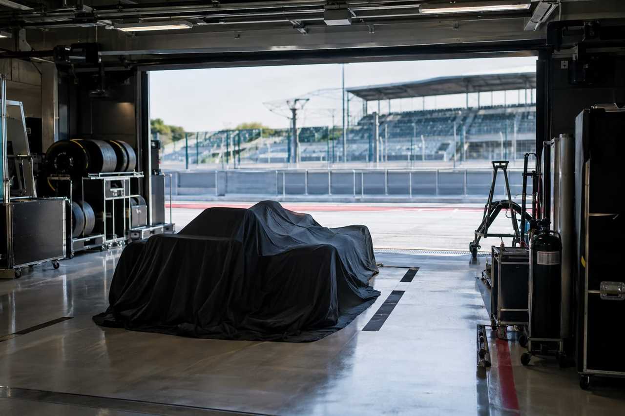 A team garage prepares for a car unveiling.