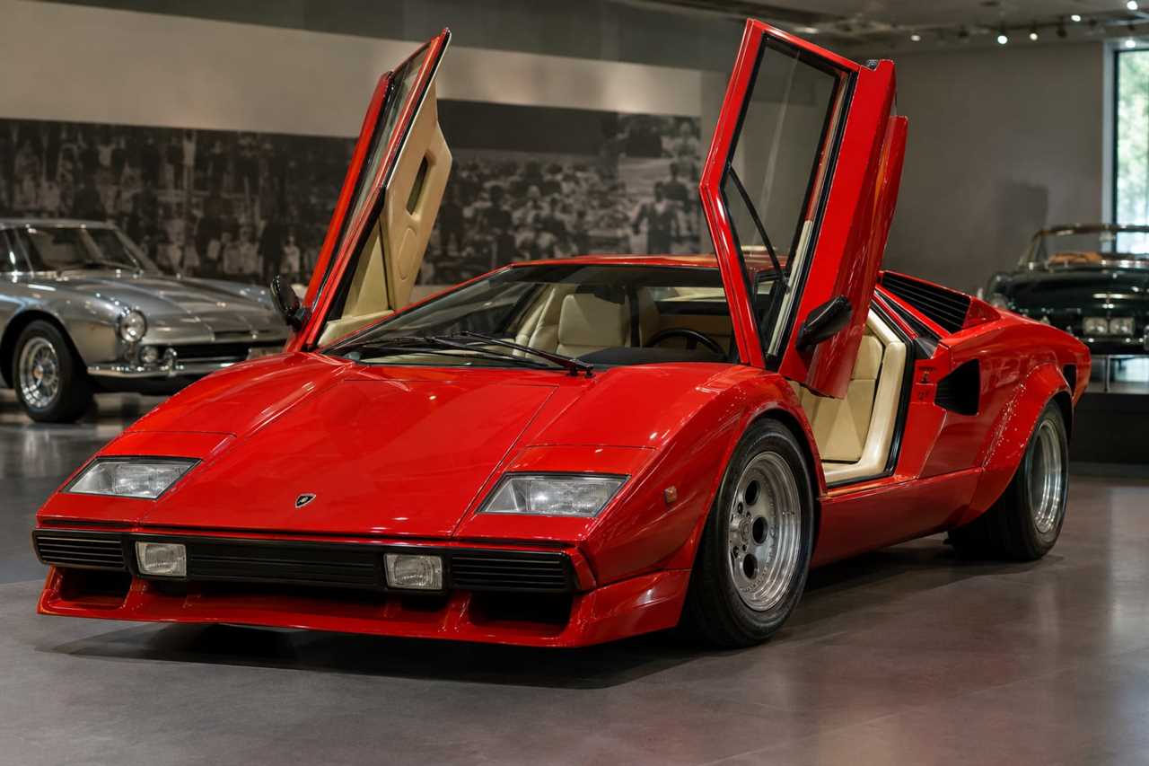 Angular scissor-door supercar displayed in a gallery setting.
