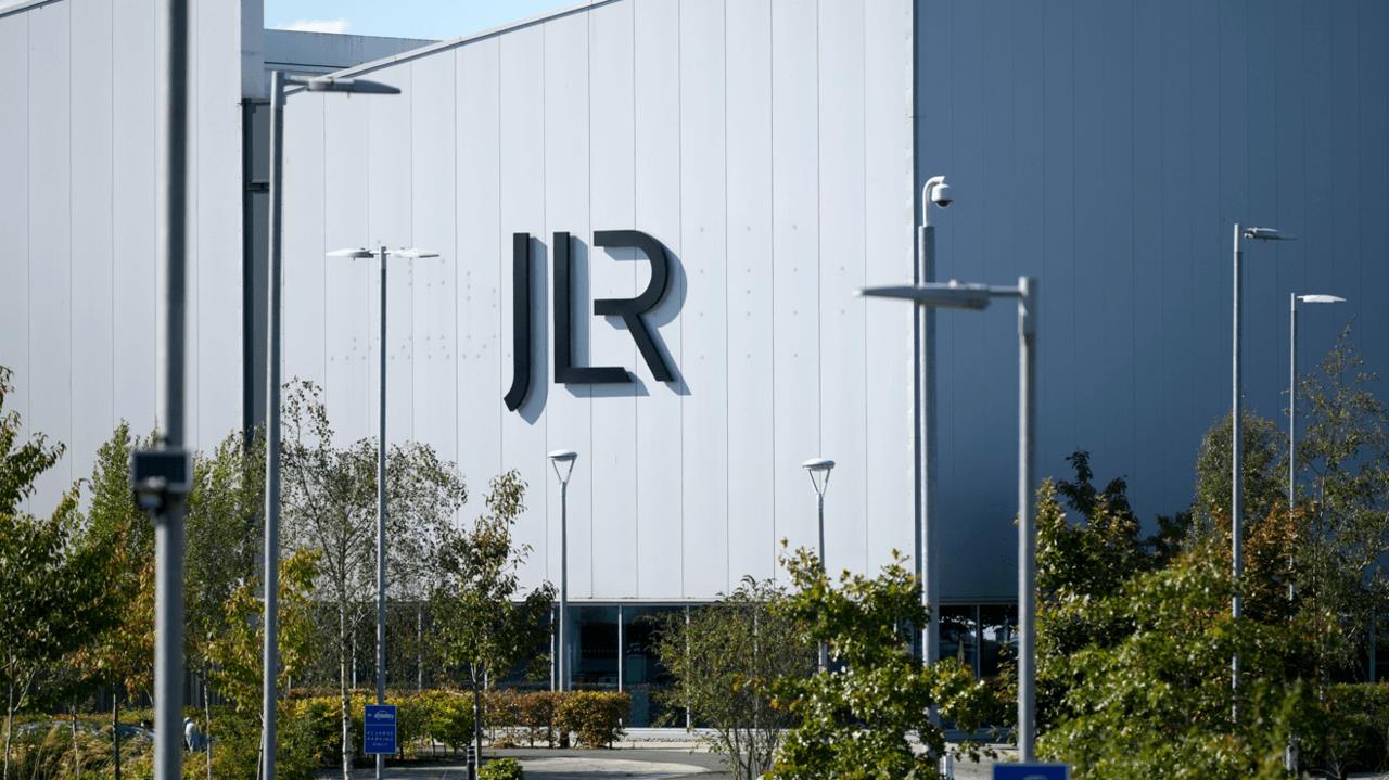 A large white building with the letters JLR in black writing on the side