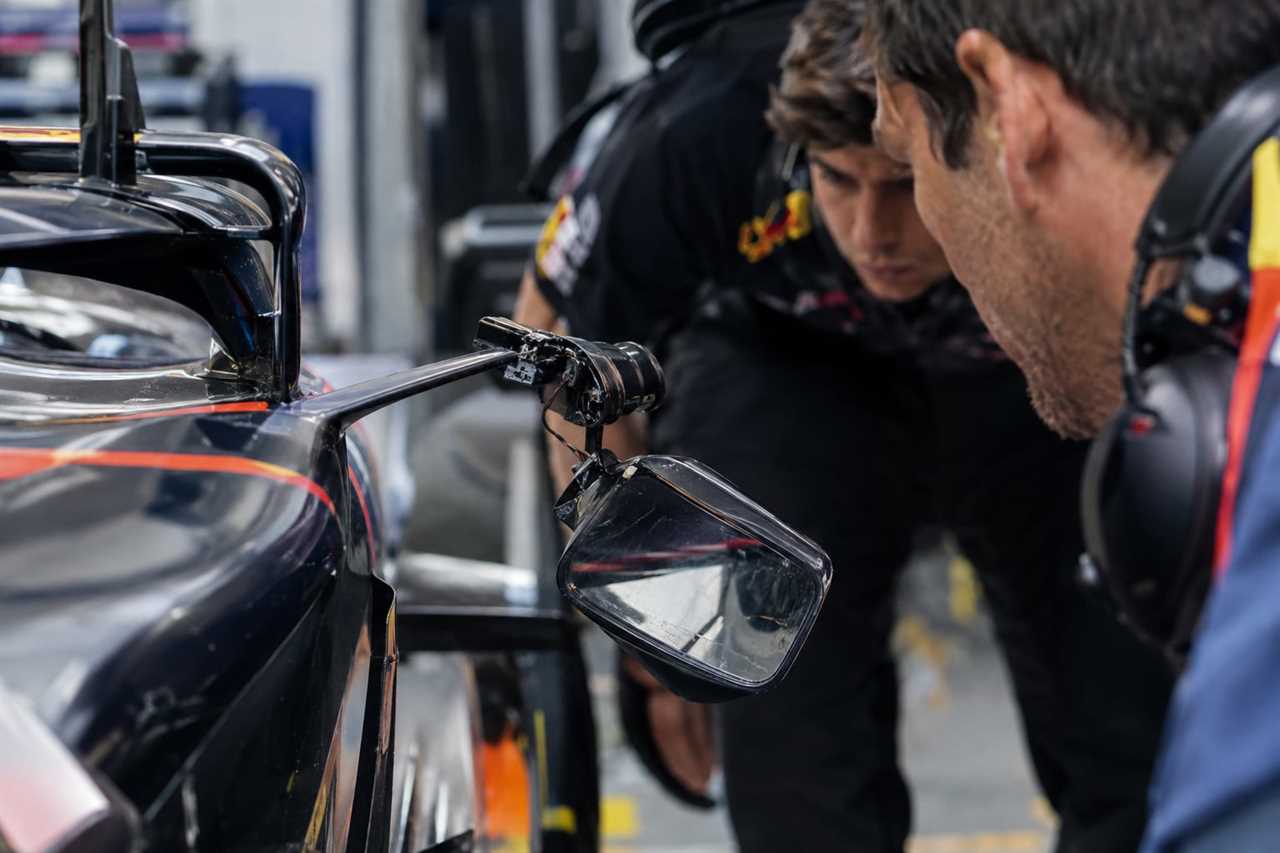 Damaged wing mirror on an F1 car in the garage.