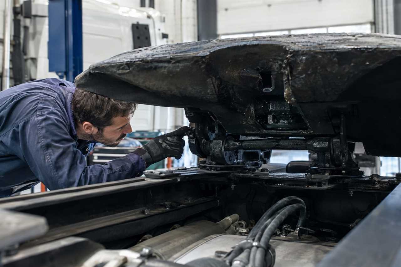 Mechanic inspecting a truck's coupling mechanism