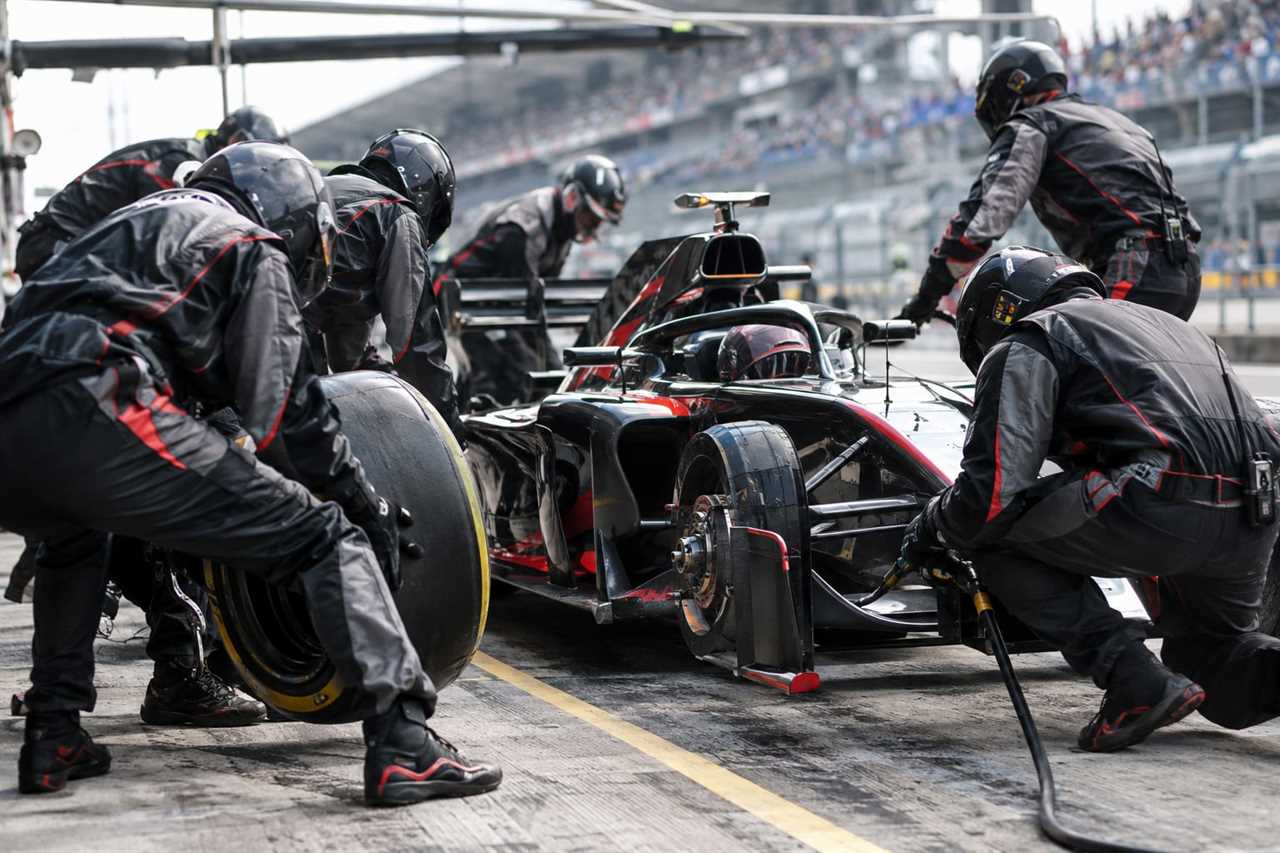 Pit crew executes a rapid tire change.