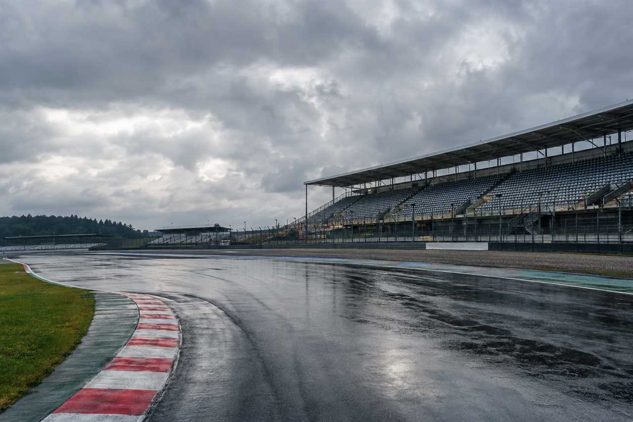 Rain-soaked racetrack under overcast skies.