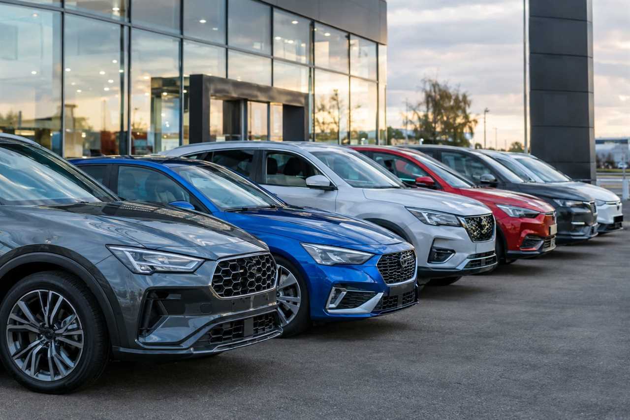 New cars with mixed engine types on a dealership forecourt.