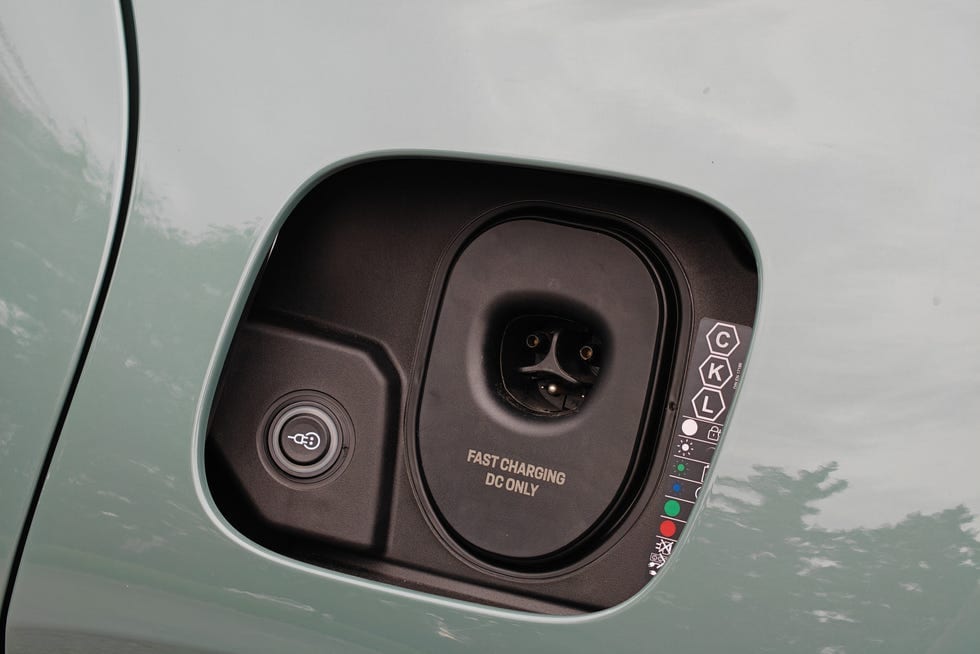 Electric vehicle charging port with indicator lights and labels for fast charging.