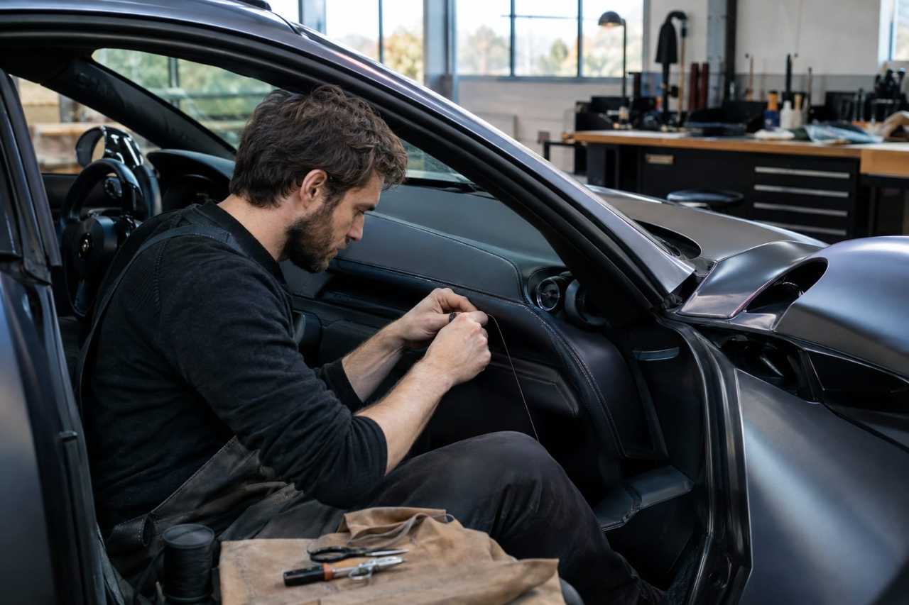 Artisan detailing a luxury car interior by hand