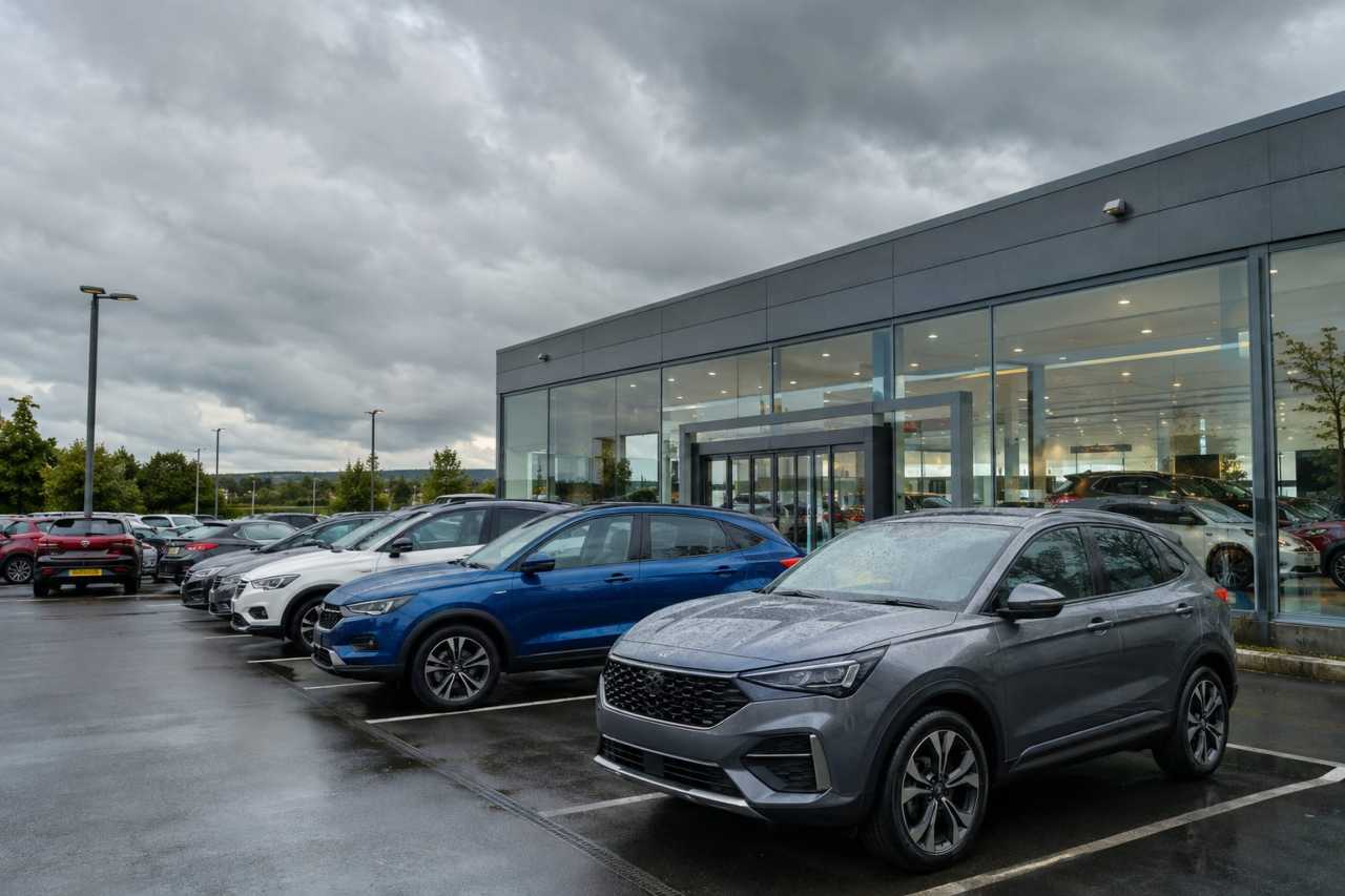 A UK car dealership forecourt with vehicles on display.