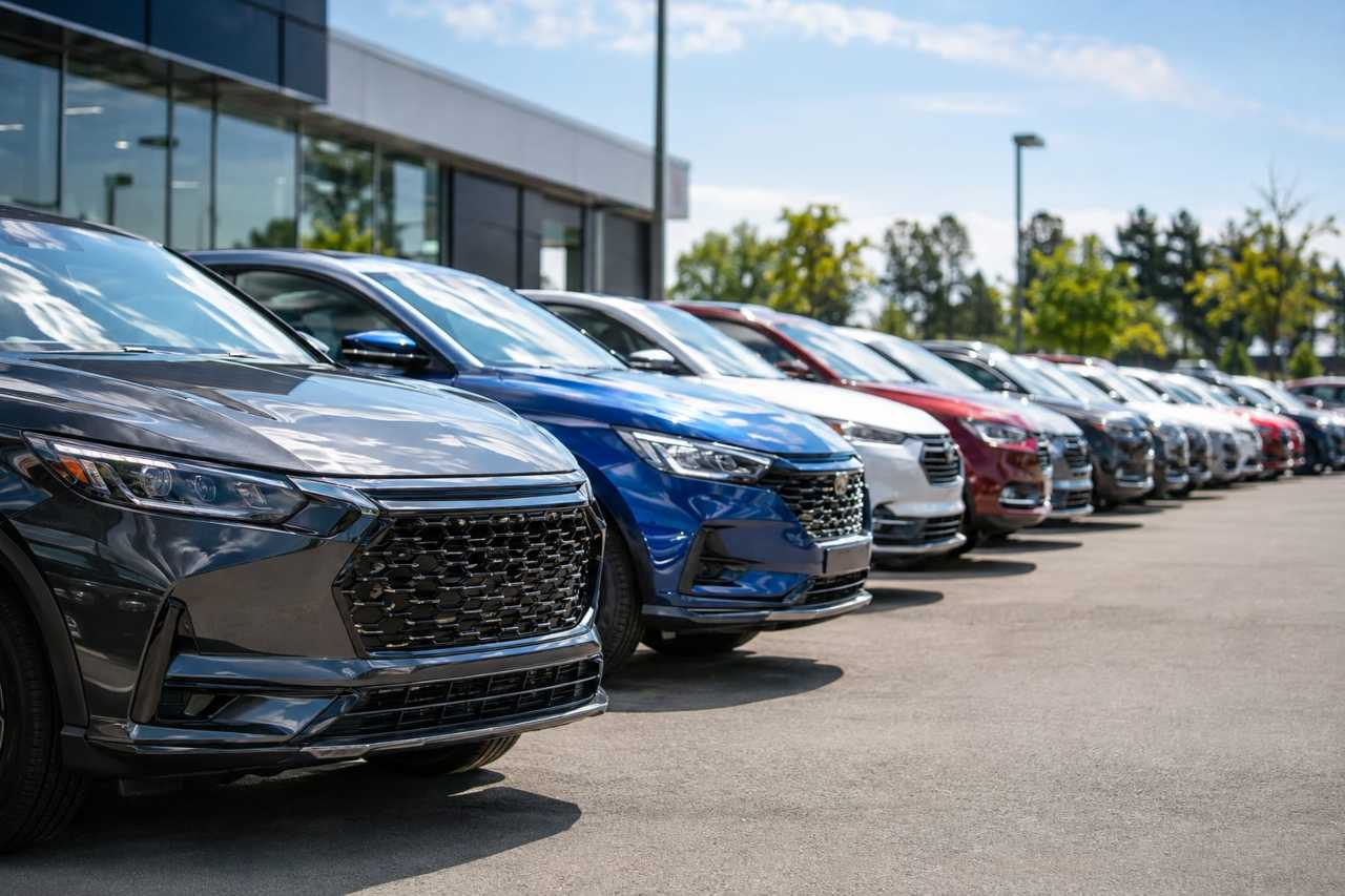 New vehicles lined up ready for sale at a dealership.